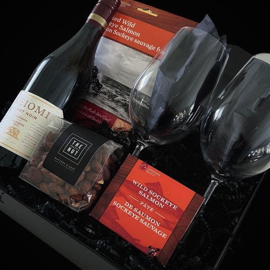 A luxury gift box featuring a bottle of Meiomi Pinot Noir, wild salmon pâté, and roasted nuts, styled for an elegant wine and food pairing experience.